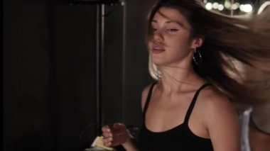 Çekici, seksi kadın uzun sarışın ve altın yuvarlak küpeler ile dans stüdyosuna, kol demiri duran ve dans etmeye başlayan, kıçını sallayarak yürüyor. Sınıf dans aynalar ve ışıkları