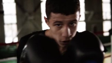 Siyah boks eldivenleri Delme ve ciddi spor salonunda kamera seyir sporcu Portait. İş gücü yorgun kapatın. güçlü beden. ağır çekim