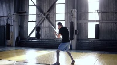 Bir erkek boxer tam uzunlukta aktif olarak eğitimler yürürken yumruklar ve sırasında taşır. Eski stil spor salonunda çabalıyormuş. Kendine güvenen erkek boxer onun eğitim yapıyor. Ağır çekim