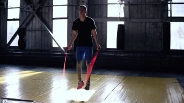Adam mavi şort bir boks spor salonunda ip atlama önden görünümü. Kardiyo egzersiz ve boks. Sağlıklı bir yaşam tarzı kavramı. Yüksek atlama ipi ile