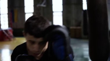 Tespit genç boksör siyah çanta vintage stilize spor salonunda Delme. Kum torbası siyah eldiven isabet Beyaz delikanlı. Yakın çekim