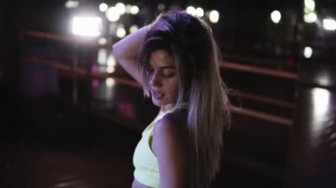 Kat twerk, breakdance dans blondy kız. Seksi kadın sarı sutyen ve gömlek koyu dans stüdyosunda poposunu sallıyor. Ayna ve soffits arka planda