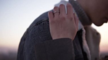 Closeup görüntülemek şehvetli kadının omuz dokunmaktan ve onun elinden okşayarak rahat genç kırmızı kafa ile duran adam. Saçları dışında ağır çekimde binanın çatısında dokunmadan. Romantik an