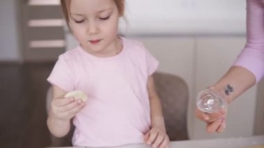Bir anne ve blondy kızı mutfak çerezleri hazırlanıyor. Tanımlama bilgisi formları kesmek için metalik formu kullanan küçük kız. Mutlu bir aile ve pişirme kavramı