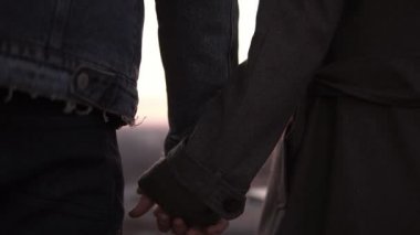 Seven çift birlikte elele ve yüksek bina çatı üzerinde duran ve gün batımını izlemek kucaklayan. Nadir görünümü kadar yakın