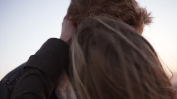 Vermelho cabeça, encaracolado jovem e sua menina de cabelos compridos abraçando enquanto estava em pé no telhado. Acariciar, ternura, amor juvenil — Vídeo de Stock