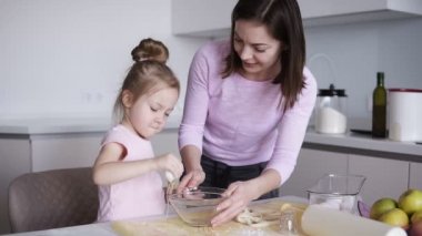 Anne ve kızı birlikte mutfakta yemek. Küçük kız kase yumurta kırma. Mutlu aile evde pasta pişirme