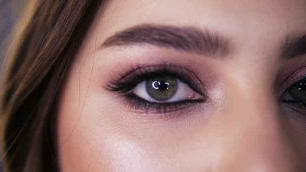 Primer plano macro retrato de cara femenina. Chica joven con ojos verdes con hermoso maquillaje y largas pestañas negras. Chica con la piel perfecta y pecas abrir los ojos — Vídeo de stock