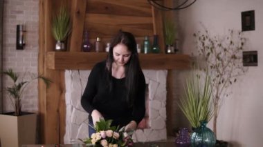 Çiçekçi önden görünümü yavaşça hazır güzel buket kurdele ile bağları. Floristik, el yapımı kavramı. Şömine arka planda