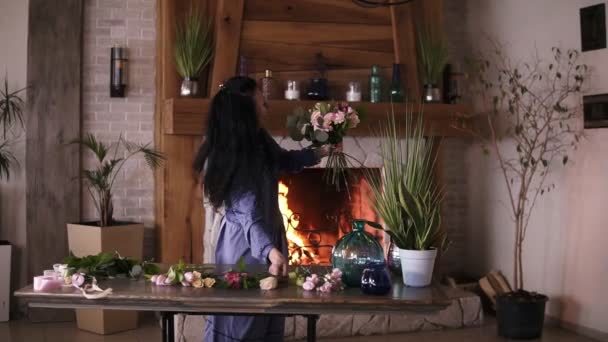 Bloemist op het werk: lachende brunette volwassen vrouw mode modern boeket van verschillende bloemen en planten maken op thuisstudio. Vooraanzicht — Stockvideo