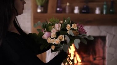 Güzel gül, pastel coloures Atölyesi'nde Lale buketi tutan esmer kadın çiçek sanatçı. Buket çiçekler ve bitkiler ile toplama. Floristik, el yapımı ve küçük işletme kavramı