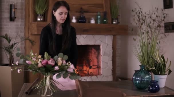 Mujer profesional artista floral, florista corte de papel de embalaje en la mesa para ramo en el taller, estudio en casa. Floristería, artesanía y concepto de pequeña empresa — Vídeos de Stock