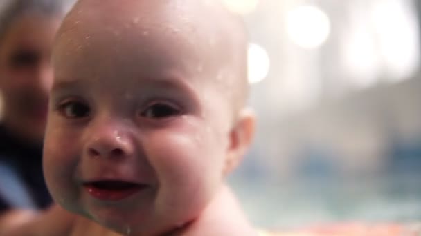 Matka lub trener uczyć chłopca do pływania w basenie kryty, trzyma go pod wodą. Happy dziecko cieszyć się pływanie w wodzie. Zbliżenie szczęśliwy Babys twarz — Wideo stockowe