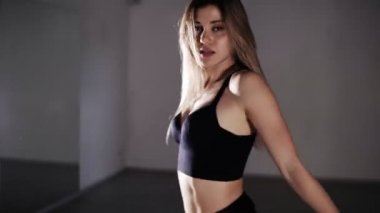 Young sexy girl dancing sensual dance on the floor. Girl doing a somersault through the head, dance twerk. Seductively looking at the camera. Accelerated footage