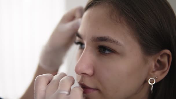 Master corrige las cejas en un salón de belleza, midiendo la forma perfecta para la cara de los clientes. Cuidado profesional de la cara y las cejas — Vídeos de Stock