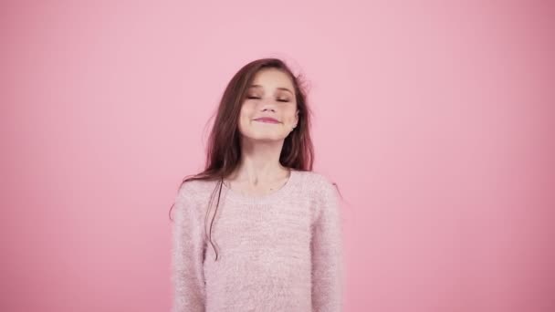 Симпатичная длинноволосая девушка, изолированная на розовом фоне, смотрящая с обеих сторон, показывая большой палец вверх, шаблон. Волнение и счастье — стоковое видео