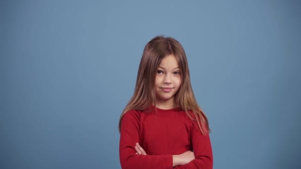 Menina de cabelos longos bonito em camisola vermelha desaprovando com nenhum sinal de mão, fazer gesto dedo negação. Negar, rejeitar, discordar. Retrato de menina bonita. Movimento lento sobre fundo azul — Vídeo de Stock