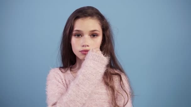 Caucasian teen girl against a blue background keeping a secret or asking for silence, zipping her mouth serious face, obedience concept — Stock Video