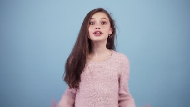 Really I cant believe it. Long haired girl excited, she is surprised and cant believe in. Covers the head with hands. Blue background isolated. Excited, funny and happy girl — Stock Video