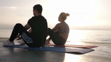 Sit ups - fitness çift egzersiz yaz aylarında thesea veya okyanus önünde dışında oturup. Uyum mutlu insanlar çapraz eğitim çalışma. Güzel genç beyaz bir çift. Yan görünüm