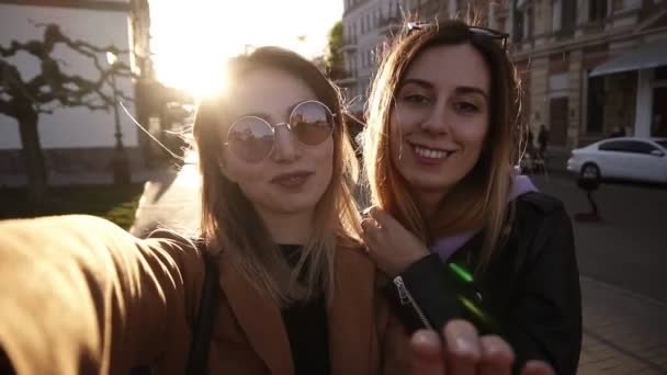 Кавказька мода жінки в сонцезахисні окуляри позує для селфі і сміятися. Дивлячись на камеру, вид спереду. Портрет життя на вулиці міста і сонячне світло на фоні — стокове відео