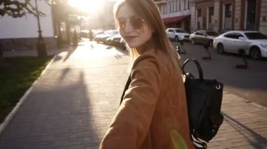 Bej ceket sarışın uzun saçlı kız güneş ışığı dolu şehir boyunca yürür. Kız adamları elini çeker. Kadın ve adam randevuda. Aşıklar el tutur. Yavaş hareket