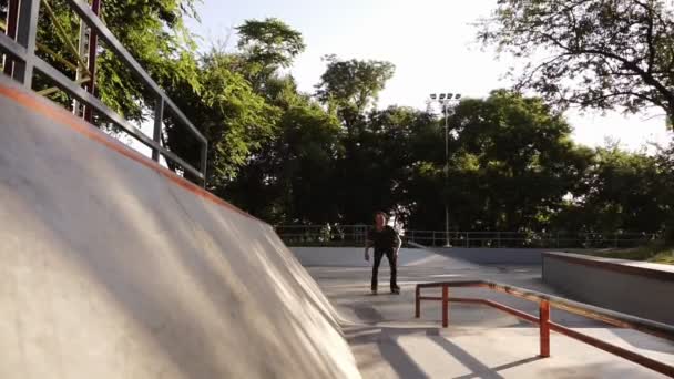 Paseo patinador en el parque. Patas de niño en línea botas duras de concha cuchillas. Haciendo trucos. Un joven que pasa su tiempo libre en el parque de skate. Deslizamiento en la pared de ángulo alto en los rodillos. Vista frontal — Vídeos de Stock