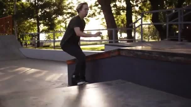 난간에서 스케이트를 타는 동안 스케이트 롤러 극단적 인 트릭 피트의 슬로우 모션 영상. 롤러 스케이트 스케이트 스케이트 공원에서 공중에서 촬영 활성 십대 촬영 스케이트 공원. 그린, 서머 타임 — 비디오
