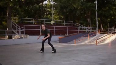 Kamu paten parkında rampada sıralı paten üzerinde çalışan determinated genç adam, bir atlama yapar ve bir süre içinde asılı. İlkbahar, yaz saati