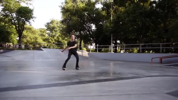 Professionele jonge man maken een 360 truc op oprit. Agressieve inline skates op Roller Skater voeten. Roller Blader het dragen van professionele inline skates in Skatepark — Stockvideo