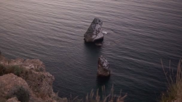 Vista sull'oceano o sul mare da una scogliera rocciosa. Veduta aerea dell'acqua blu che si scontra tranquillamente con scogliere e rocce. Roccia solitaria in mezzo al mare — Video Stock