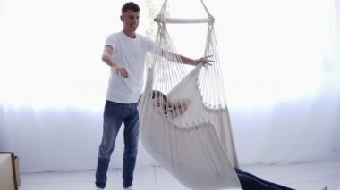 Beyaz kocayı sevmek, karısını sallamak. İkisi de birlikte eğleniyor. Beyaz renkli iç oda içinde hamak dinlenme Kız