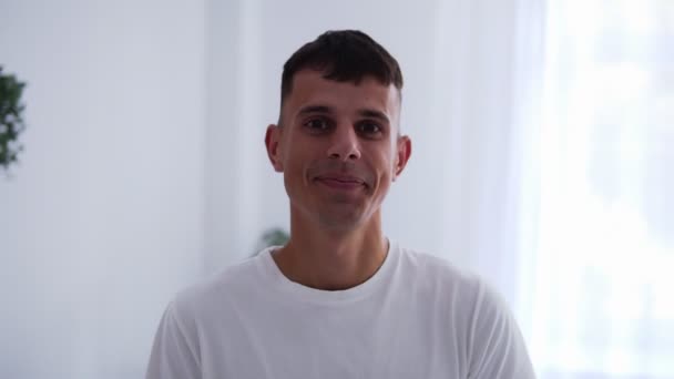 Fiatal jóképű férfi portréja barna srác mosolygó vidám élvezi életmód változás sikeres férfi a lakásban háttérben — Stock videók
