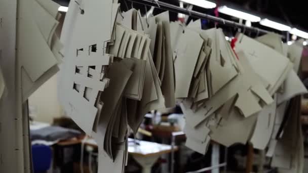 Γκρο πλαν επισκόπηση των προτύπων στένσιλ κρέμονται στο στούντιο ράφτη. Δείγματα που χρησιμοποιούνται στο σχεδιασμό ρούχων, την προσαρμογή. Εικόνα του στούντιο ράφτη με γυναίκες εργαζόμενες σε διαδικασία — Αρχείο Βίντεο