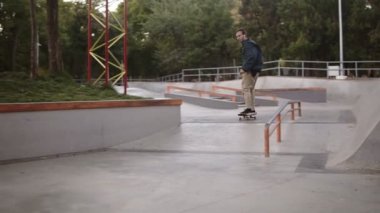 Kaykaycılar konsepti. Genç patenci paten kayarken aşırı numara yapıyor. Kaykay parkında kaykay yaparken havada vurulan aktif bir adam, sokak yavaş çekim kickflip. Açık havada.