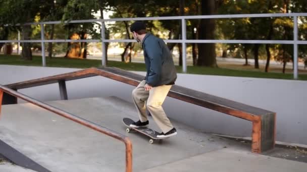 Unga skridskor rullar extrema trick fötter medan skridskor på räcken. Aktiv tonåring skjuten i luften i rullskridskor i en skatepark. Grön, sommartid. Långsamma rörelser — Stockvideo