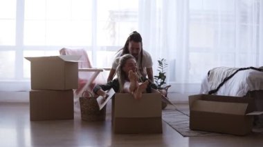 Mutlu, şık bir çift yeni evde birlikte eğleniyor. Bavulları boşaltmaya ara verdim. Kız karton kutuya biniyor, kocası onu itip duruyor. Yeni bir dairede birlikte mutlu vakit geçirin. Yavaş çekim