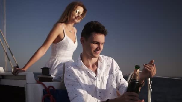 Два человека на курорте, счастливая семейная пара пьет шампанское на яхте, отдыхает на воде, романтическая пара пьет напиток к морю, бокалы в руках мужское предложение и женщина на заднем плане — стоковое видео