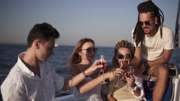 Gli amici trascorrono un fine settimana su uno yacht. Evento sullo yacht. L'allegra compagnia festeggia un compleanno su uno yacht. Gruppo di quattro stanno stringendo con i bicchieri champange — Video Stock