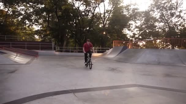 현대 스케이트 공원의 경마장 트랙에서 자전거를 타며 위험 한 움직임을 연습하고 공중 회전 연습을 하는 극단적 인 쿨 자전거 선수 — 비디오