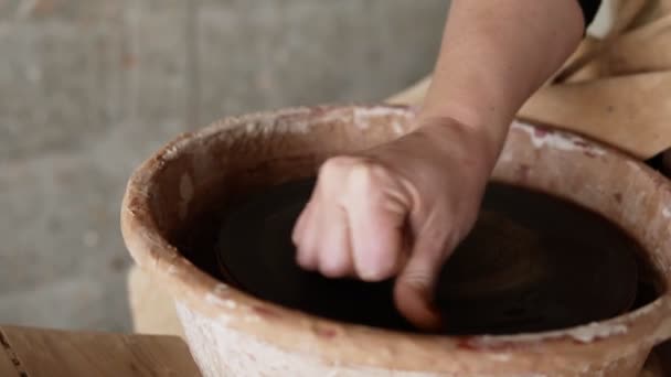 Fermer les images des mains féminines mouiller la surface vide de la roue du potier avant le travail. Sculpteur sculpte des pots produits. Maître Crock. Les potiers travaillent en gros plan — Video