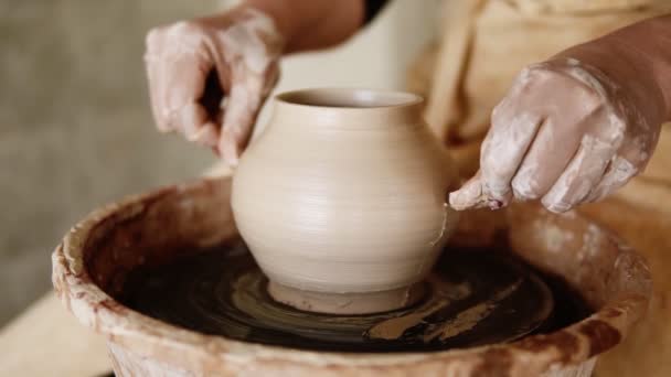 Il vasaio femmina taglia la base del vaso con una lenza da pesca e divide il vaso in due metà. Ragazza rende ceramica da argilla da vicino. Fare prodotti ceramici da argilla bianca — Video Stock