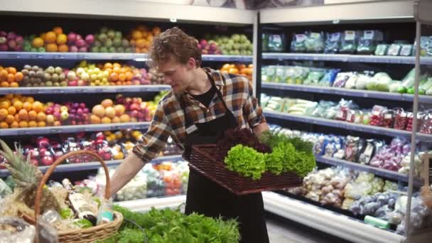 Barra de ensaladas con verduras y verduras ecológicas en el supermercado. Hombre empleado de la tienda que organiza verduras frescas en un bar en el supermercado local — Vídeo de stock