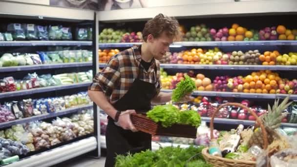 Salatbar mit Bio-Gemüse und Gemüse im Supermarkt. Männliche Verkäuferin arrangiert frisches Gemüse an einer Bar im örtlichen Supermarkt. Zeitlupe — Stockvideo