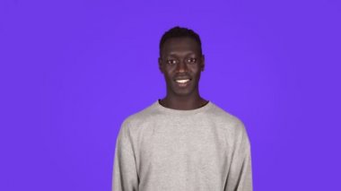 Mavi arka planda beyaz tişörtlü kısa saçlı Afro-Amerikan bir adam. Konuşan, erkek elini tutup konuşuyor, fısıldıyor. Gevezelik Kavramı, Dedikodu, Konuşma
