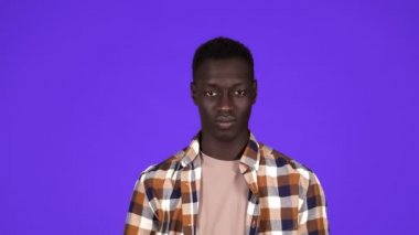 Kaygısız afro amerikan sakallı adamın portresi mavi arka planda izole edilmiş hiçbir ipucu olmadığını söyleyerek omuz silkiyor. Duyguların kavramı