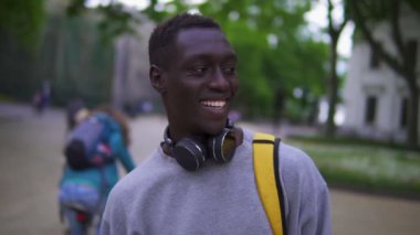Yakışıklı, Afro-Amerikalı genç bir adamın yakın portresi kameraya gülümseyen sakin bir şehir akşamının tadını çıkaran seyahat yaşam tarzı.