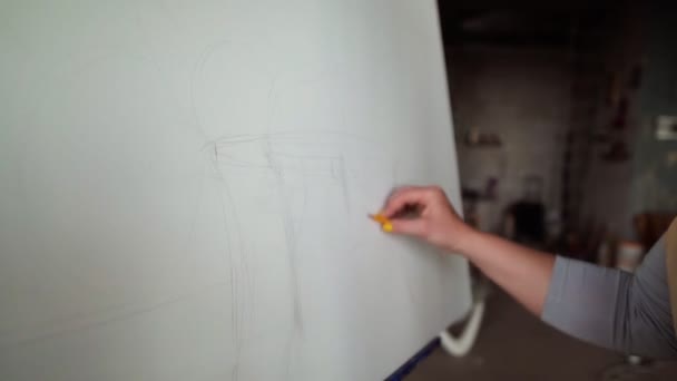 Oigenkännlig ung designer kvinna i beige förkläde ritning skiss på duk med hjälp av grå penna medium shot — Stockvideo