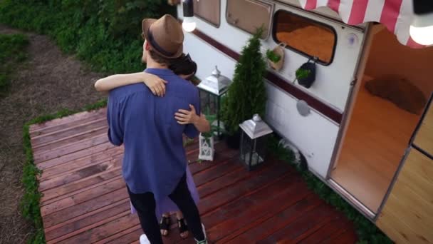 Joven pareja caucásica bailando lento baile abrazando delante del remolque, ruedas de la casa. Feliz amante hombre y mujer citas al aire libre. Romance, amor eterno, ocio, estilo de vida, unidad. Vista de ángulo alto — Vídeos de Stock