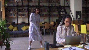 Halk kütüphanesini aç. Arkadaşı derslerine yoğunlaşırken ve masada dizüstü bilgisayarla çalışırken, kulaklıklı neşeli bir esmer arka planda dans ediyordu. Yavaş çekim